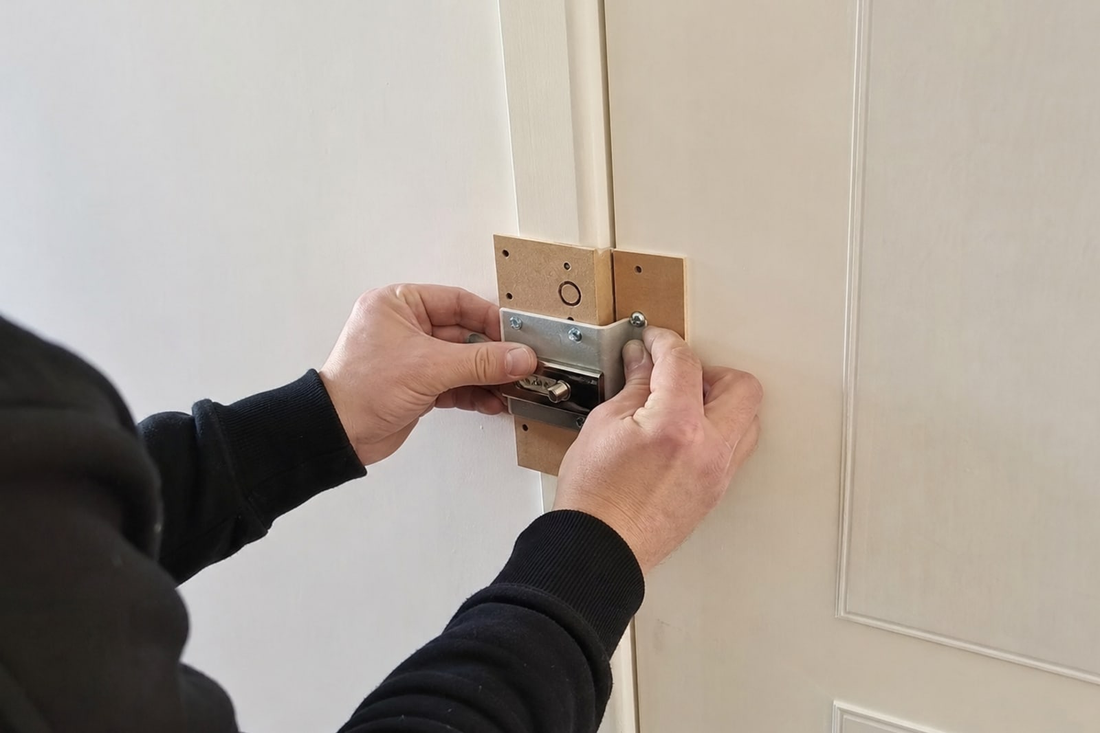 mains ajustant un verrou supplémentaire sur porte