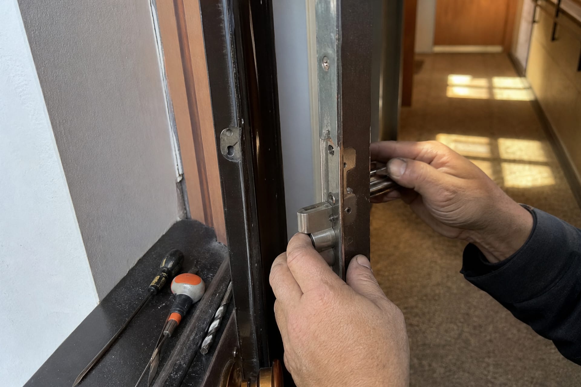 mains ajustant serrure sur porte palière métallique