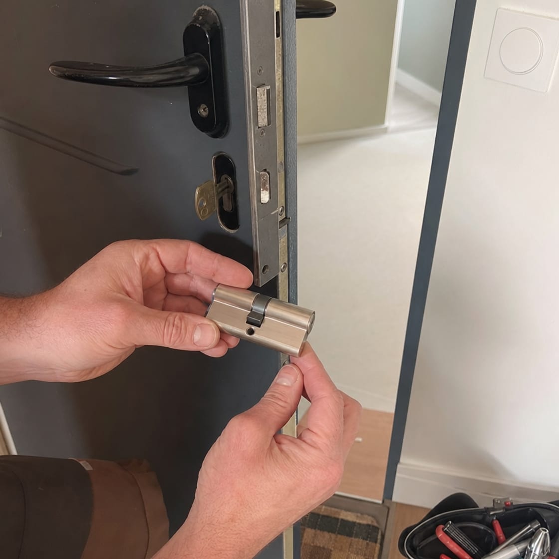mains remplaçant un cylindre de serrure